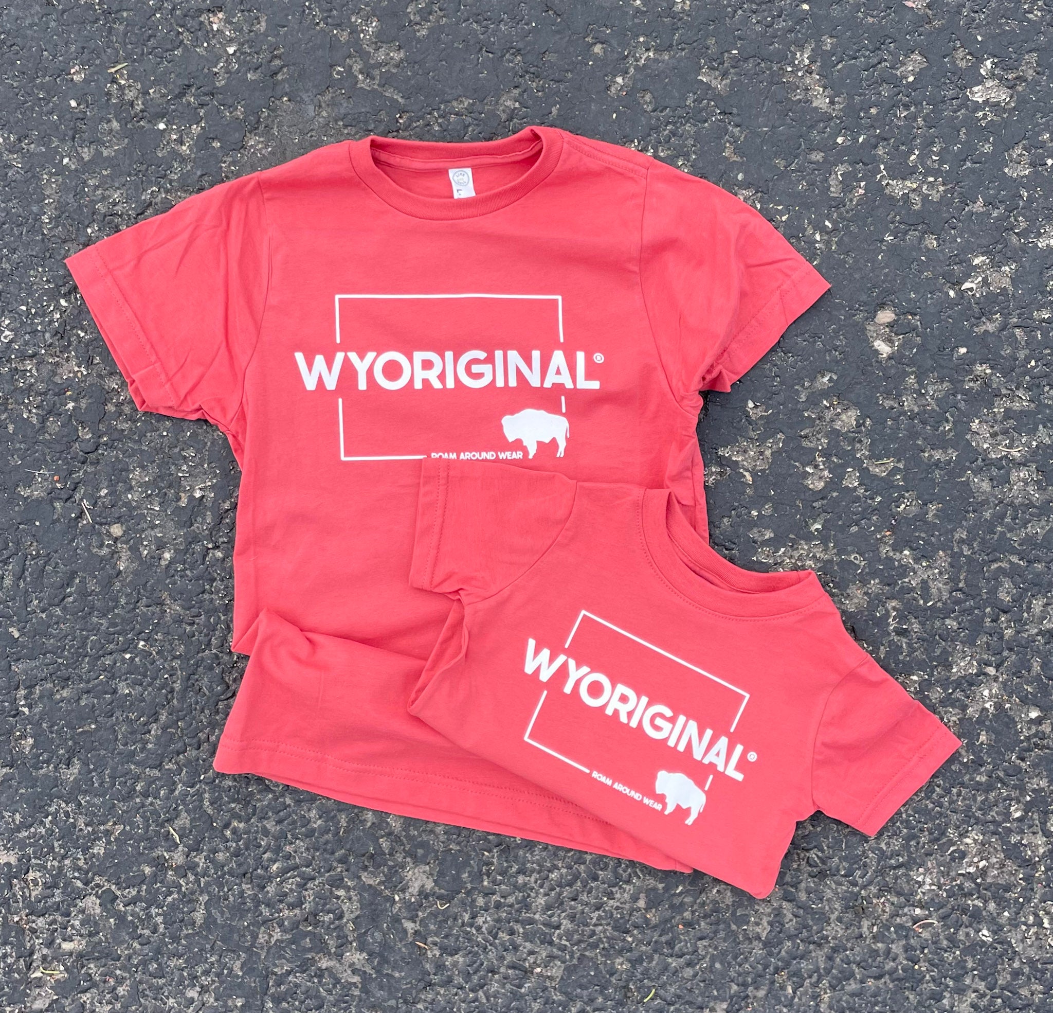 Wyoriginal Square State design in white on red/orange shirt. Roam Around Wear is a women owned Wyoming T-Shirt company based out of Gillette, Wyoming.